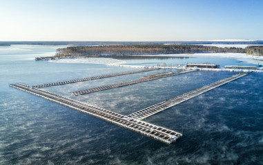 Aerial shot of the floating fish farm at the steaming lake in the Russia