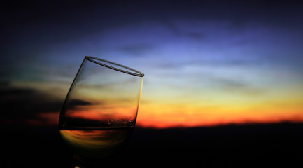 Fototapeta na wymiar glass of wine at sunset