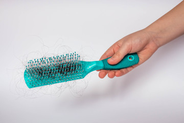 Girl Hairs fall with a comb and problem hair on white background. Hair fall or loss with blush is a problem of women.