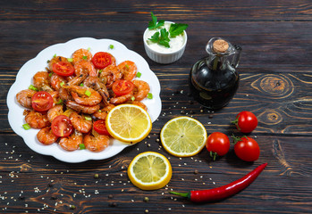 Baked shrimp with lemon and vegetables in a plate