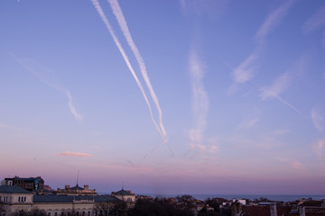 airplane trails over the city skyline 