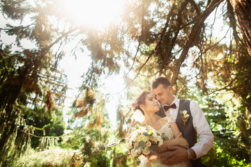 Beautiful sunny day. Wedding couple posing on the background of nature