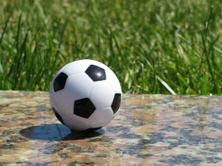 Fototapeta na wymiar Soccer ball on green grass background. Football arena, summer match