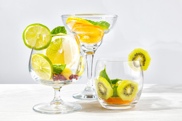 Three glasses for cocktails with fruit and berries without liquid