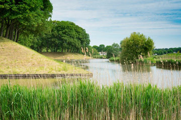water landscape with canal, dike and trees in fortified village Klundert, The Netherlands