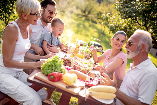 Family have lunch at summer party - Powered by Adobe