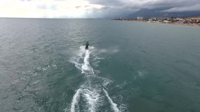 video shows quick standup-jetski racing turns in water, filmed on the south coast of spain, marbella, malaga, spain. 
shows water sports racing from a fimled from drone in 4k