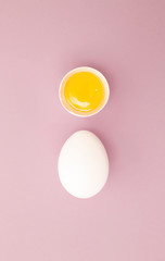 Chicken white egg with raw broken yellow yolk. Top view.  