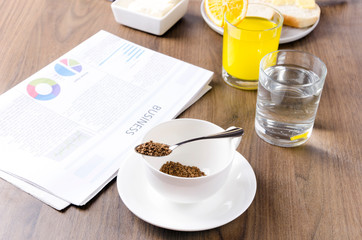 Concept of business breakfast.Quickly prepare coffee, glasss of water,orange juice, newspaper.Businessman`s morning
