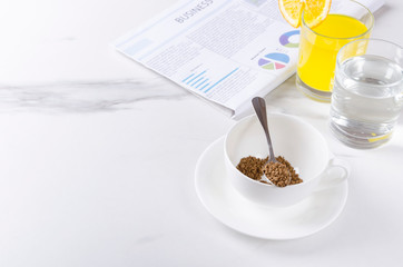 Morning breakfast with fresh newspaper.Instant coffee, glass of water and orange juice.Concept of business breakfast.Empty space for your design