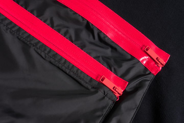 Black pockets on clothes with two pink water resistant zippers. Stylish furniture.