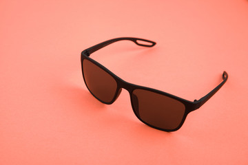 Sunglasses on color background