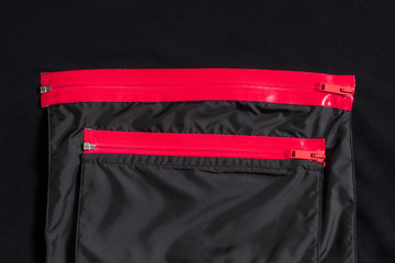 Black pockets on clothes with two pink water resistant zippers. Stylish furniture.