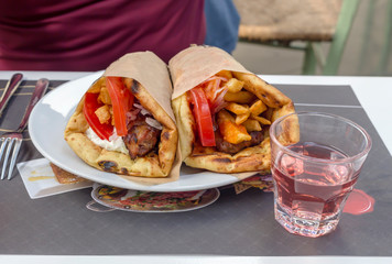 The traditional Greek snacks grilled (soufflaki) and a glass of wine close-up