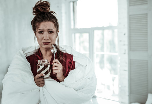 Sad woman eating the chocolate pasta to reduce the stress