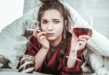 Stressed woman performing bad habits while being depressed