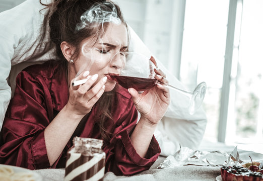 Depressed Woman Drinking Smoking And Eating A Lot