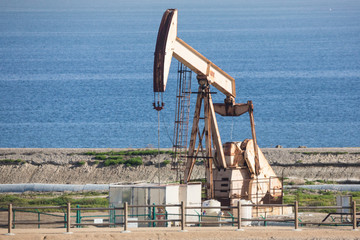 Fototapeta premium Oil derrick pumps sludge on the beach west coast