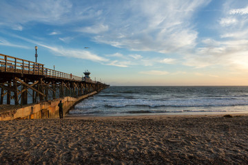 Fototapeta na wymiar Sunset over an ocean pier on the west coast