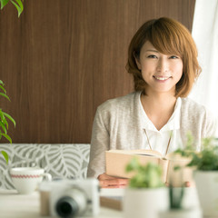 本を持ち微笑む女性