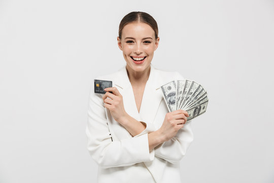 Photo of charming businesswoman 20s wearing elegant jacket holding fan with dollar money banknotes and credit card