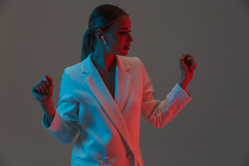 Photo closeup of joyful woman 20s wearing earpods listening to music and dancing while standing...