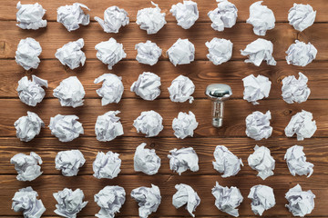 Ideological concept with wastepaper light bulb on wooden table