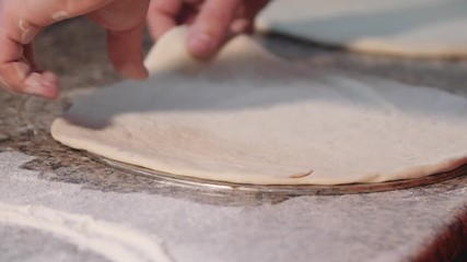 Close up hands of young pizza maker in apron preparing dough. Chef make pizza. 4k