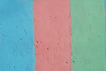 Fragment of bright painted concrete plastered wall. Striped rainbow background. Rough wall texture