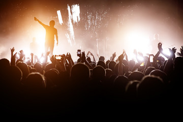 Rock concert. Leader on the stage. Silhouette of the crowd in front of the stage.