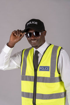 Salisbury, Wiltshire, UK. April 2019. Portrait of a smiling police officer in uniform and holding a pair of dark glasses.