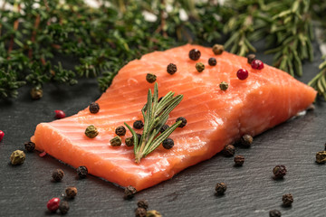 Raw salmon, trout fillet on a dark slate background. Wild atlantic fish. Healthy food.