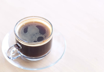 Closeup glass of hot americano coffee on wood table, selective focus, vintage tone