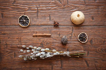 Willow catkins with spices on wooden background. Easter concept.