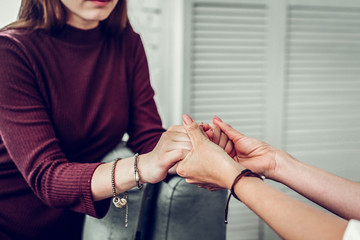 Client of family therapist wearing dark sweater shaking hands