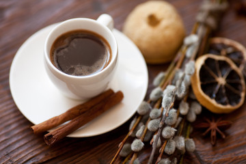 Coffee cup and willow branches, dry lemon, cinnamon.