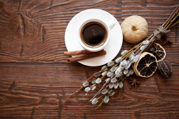 Fototapeta na wymiar Coffee cup and willow branches, dry lemon, cinnamon.