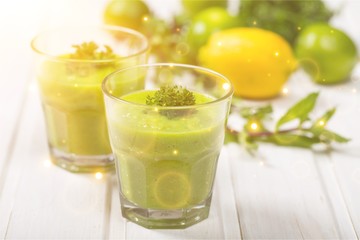 Green vegetable smoothies in glasses on wooden table