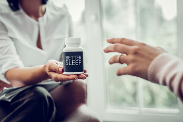 Client of therapist wearing ring taking pills for better sleep