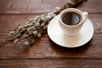Pussy-willow branch wreath with buds and cup of tea coffee