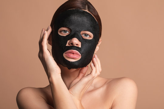 Pretty lady touching her face while having black mask on it