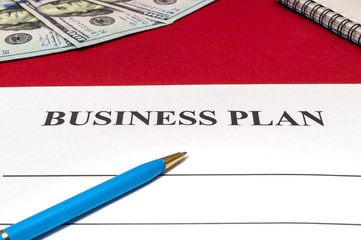 Strategy business plan with pen and money on red table.