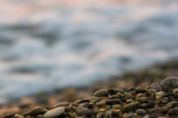 pebble stones on the sea beach, the rolling waves of the sea with foam