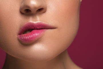 Woman biting her lip isolated on the maroon background