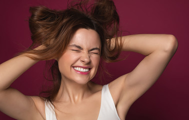 Expressive woman smiling and messing her hair up