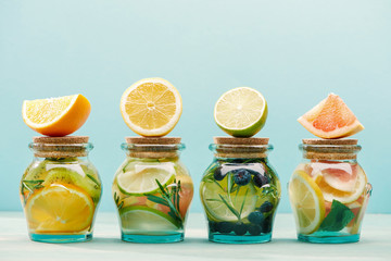 fresh detox drinks in jars with ingredients isolated on blue