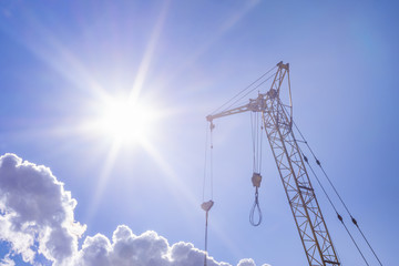 construction crane on a bright Sunny day concept of building and construction of houses