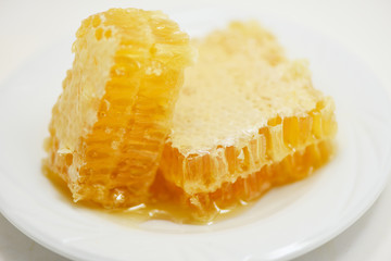 Fresh honey / Close up of yellow sweet honeycomb slice on white plate natural healthy food