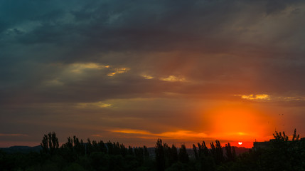 Landscape with dramatic light - beautiful golden sunset with saturated sky and clouds.