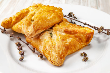 Fresh buns with vegetable filling and dried spice on a white plate.